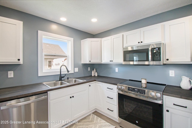 304 W Gibbs St, Saint Johns, MI 48879 - kitchen with appliances with stainless steel finishes, white cabinets, recessed lighting, butcher block counters, and light wood-style floors