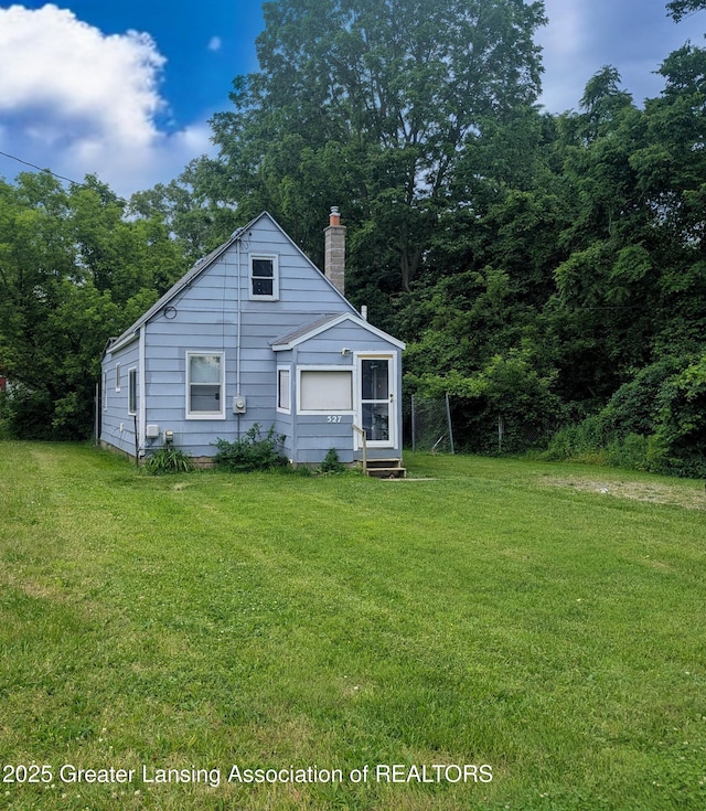 527 S Charles St, Lansing, MI 48912 - view of front of property with a front yard and a chimney