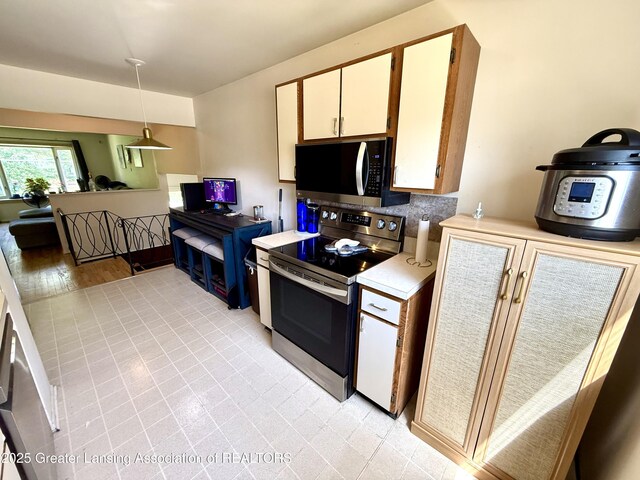 3618 Alpine Dr, Lansing, MI 48911 - kitchen featuring appliances with stainless steel finishes, light countertops, decorative light fixtures, and light tile patterned flooring