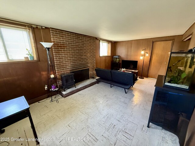 3618 Alpine Dr, Lansing, MI 48911 - living room featuring a wood stove, wood walls, and tile patterned floors