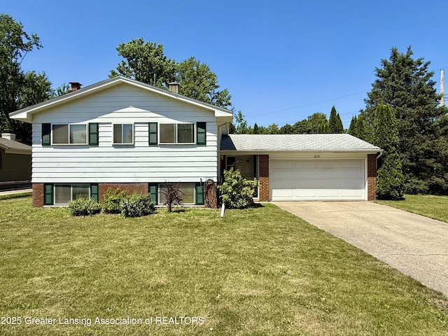 3618 Alpine Dr, Lansing, MI 48911 - tri-level home featuring a garage, concrete driveway, a front lawn, and brick siding