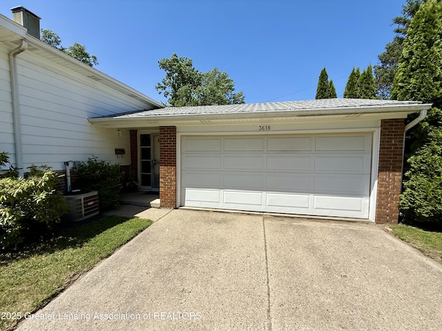 3618 Alpine Dr, Lansing, MI 48911 - view of front of house featuring brick siding, concrete driveway, and a garage