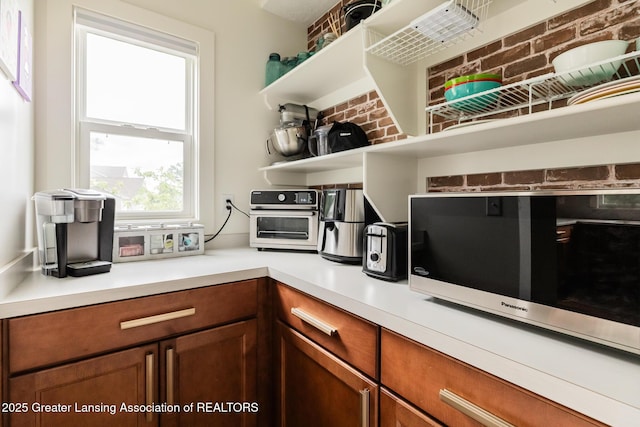 9655 Tobermory Dr, Haslett, MI 48840 - kitchen with open shelves, light countertops, and brown cabinetry