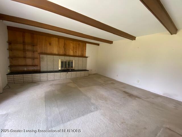 12906 Bilmar Ln, Grand Blanc, MI 48439 - unfurnished living room with beamed ceiling, carpet floors, and a fireplace