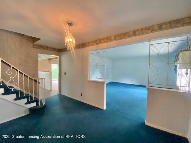 12906 Bilmar Ln, Grand Blanc, MI 48439 - carpeted empty room featuring stairs and a chandelier