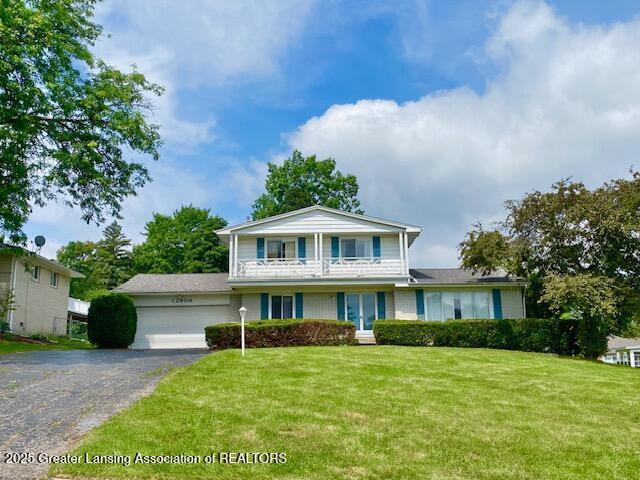 12906 Bilmar Ln, Grand Blanc, MI 48439 - traditional home with a garage, driveway, a front lawn, and a balcony