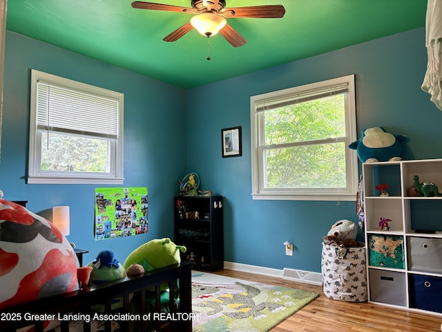 1023 E Colonial Park Dr, Grand Ledge, MI 48837 - bedroom with multiple windows, wood finished floors, and a ceiling fan