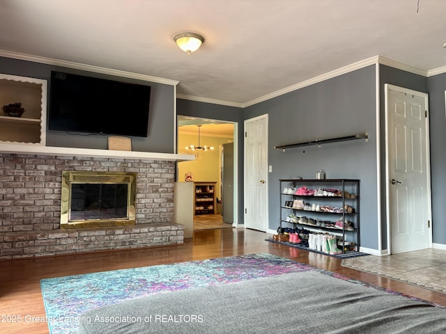 1023 E Colonial Park Dr, Grand Ledge, MI 48837 - living area with wood finished floors, crown molding, a fireplace, and a chandelier