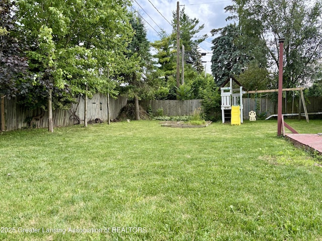 1023 E Colonial Park Dr, Grand Ledge, MI 48837 - fenced backyard with a playground