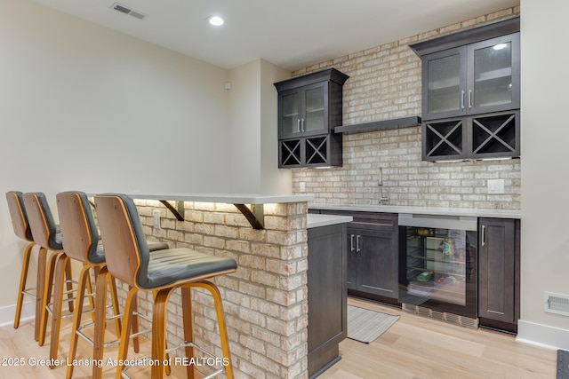 6075 Sacramento Way E, Lansing, MI 48823 - indoor dry bar with beverage cooler, light wood finished floors, backsplash, and recessed lighting