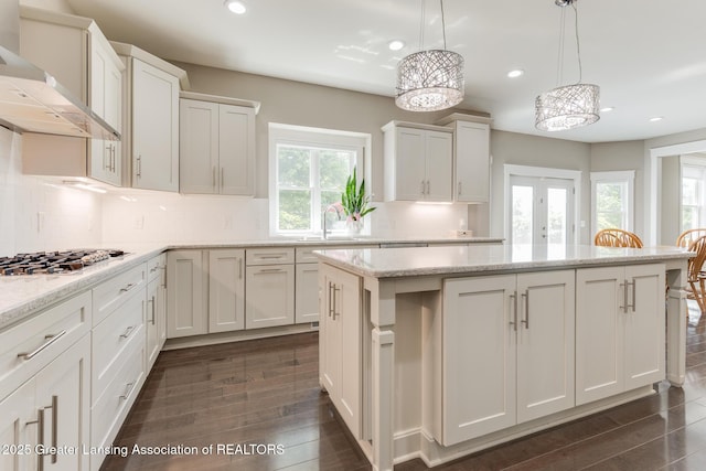 6075 Sacramento Way E, Lansing, MI 48823 - kitchen with wall chimney range hood, stainless steel gas stovetop, recessed lighting, a kitchen island, and backsplash