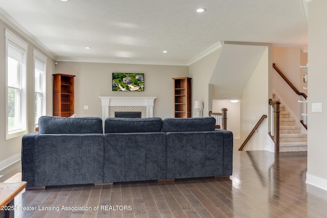 6075 Sacramento Way E, Lansing, MI 48823 - living area with a tile fireplace, wood finished floors, ornamental molding, stairs, and recessed lighting