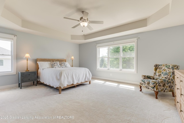 6075 Sacramento Way E, Lansing, MI 48823 - bedroom with a tray ceiling, light carpet, and ceiling fan