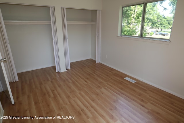 3700-3702 Malibu Dr, Lansing, MI 48911 - unfurnished bedroom featuring multiple closets and light wood-style flooring