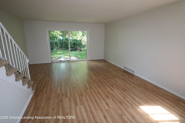 3700-3702 Malibu Dr, Lansing, MI 48911 - unfurnished living room featuring light wood-type flooring and stairway