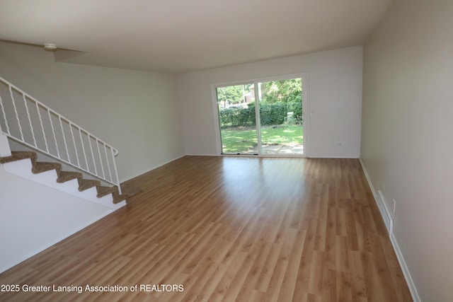 3700-3702 Malibu Dr, Lansing, MI 48911 - unfurnished living room featuring light wood finished floors and stairway