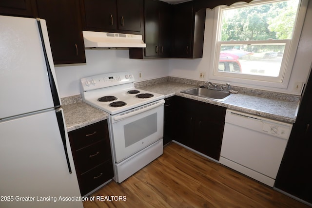 3700-3702 Malibu Dr, Lansing, MI 48911 - kitchen featuring white appliances, under cabinet range hood, wood finished floors, light countertops, and dark cabinetry