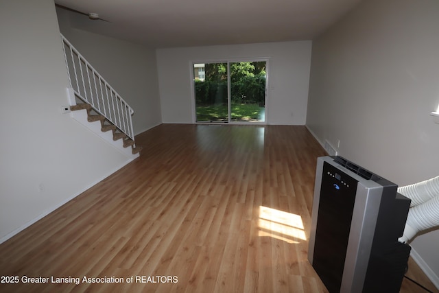 3700-3702 Malibu Dr, Lansing, MI 48911 - unfurnished living room with wood finished floors and stairway
