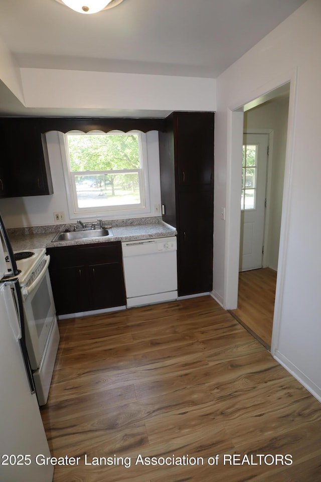 3700-3702 Malibu Dr, Lansing, MI 48911 - kitchen with white appliances, wood finished floors, light countertops, and white cabinetry