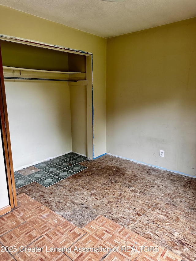 1115 Rose Ave, Big Rapids, MI 49307 - unfurnished bedroom featuring a closet and a textured ceiling