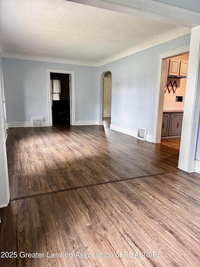 1115 Rose Ave, Big Rapids, MI 49307 - empty room with arched walkways and wood finished floors