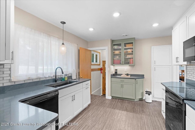 1395 Biscayne Way, Haslett, MI 48840 - kitchen with black appliances, dark countertops, light wood-style floors, hanging light fixtures, and recessed lighting