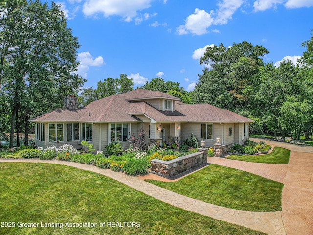 10696 W Clark Rd, Eagle, MI 48822 - traditional home featuring a front lawn, a chimney, and roof with shingles