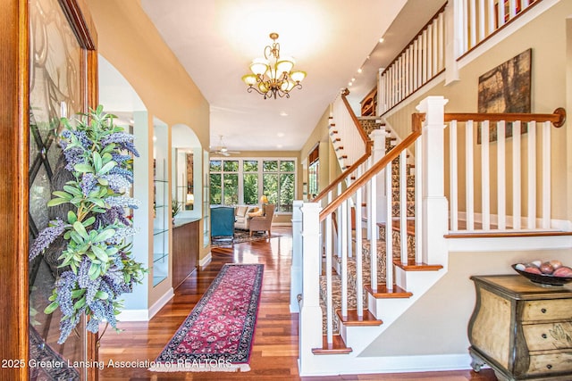 10696 W Clark Rd, Eagle, MI 48822 - entryway with wood finished floors, stairway, a chandelier, arched walkways, and recessed lighting