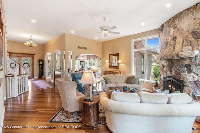 10696 W Clark Rd, Eagle, MI 48822 - living room with arched walkways, a chandelier, wood finished floors, a stone fireplace, and recessed lighting