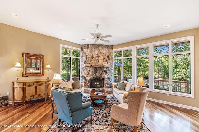 10696 W Clark Rd, Eagle, MI 48822 - living room featuring ceiling fan, wood finished floors, a stone fireplace, and recessed lighting