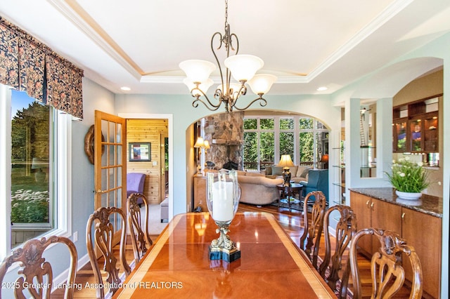 10696 W Clark Rd, Eagle, MI 48822 - dining area with arched walkways, a raised ceiling, a chandelier, crown molding, and recessed lighting