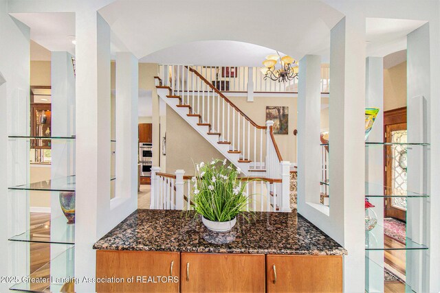 10696 W Clark Rd, Eagle, MI 48822 - entryway featuring a chandelier, stairway, and arched walkways