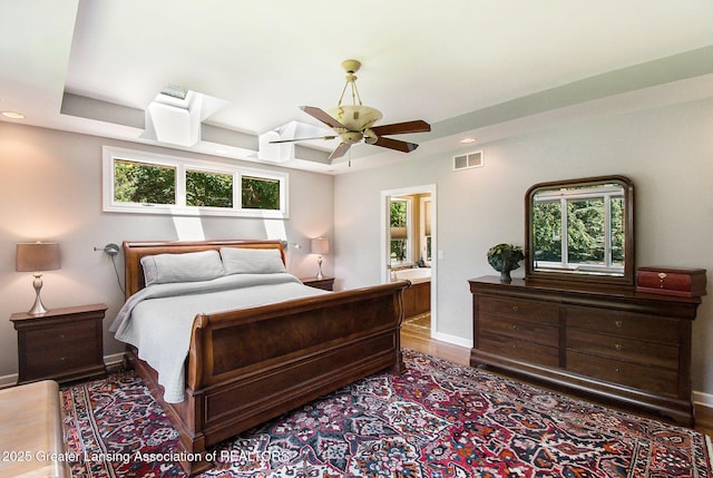 10696 W Clark Rd, Eagle, MI 48822 - bedroom with wood finished floors, recessed lighting, a tray ceiling, a ceiling fan, and ensuite bath