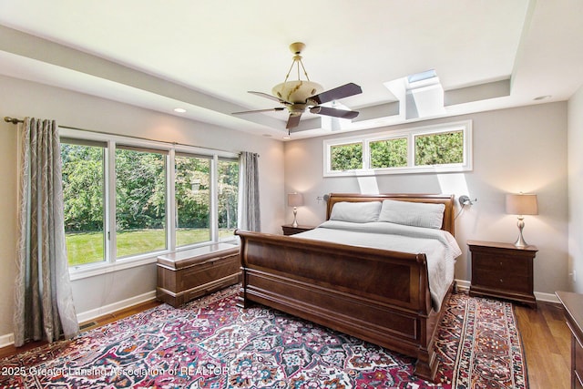 10696 W Clark Rd, Eagle, MI 48822 - bedroom with wood finished floors, a raised ceiling, a skylight, and ceiling fan