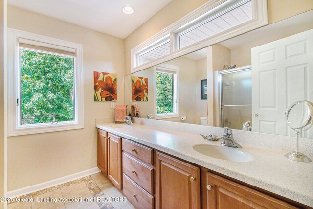 10696 W Clark Rd, Eagle, MI 48822 - bathroom featuring double vanity, healthy amount of natural light, a shower stall, tile patterned floors, and recessed lighting