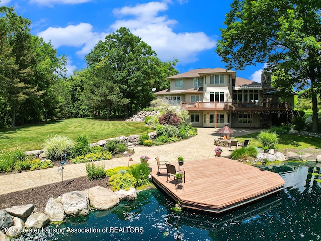 10696 W Clark Rd, Eagle, MI 48822 - back of property featuring an outdoor fire pit, a lawn, a patio area, and a deck
