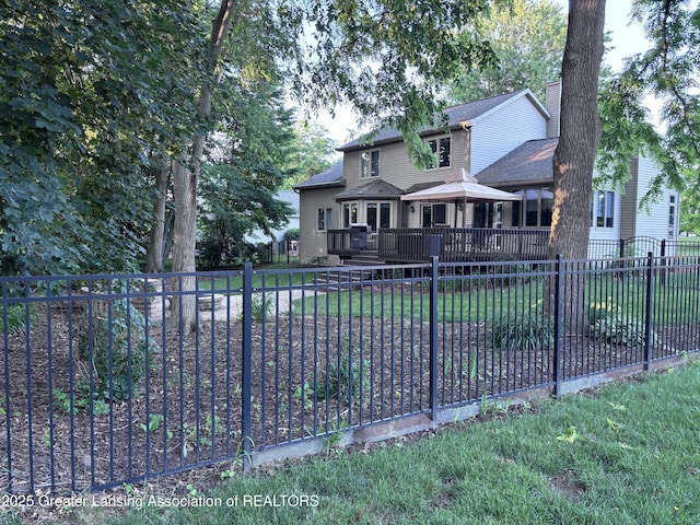 2665 Allium Dr, Holt, MI 48842 - traditional-style house with a deck, a fenced backyard, a chimney, and roof with shingles