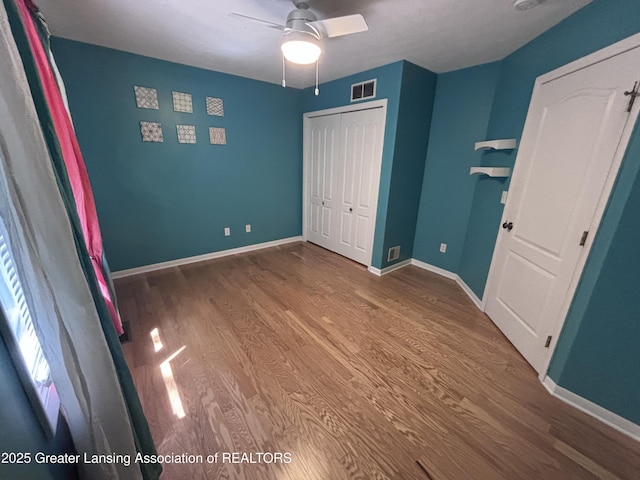 2665 Allium Dr, Holt, MI 48842 - unfurnished bedroom featuring wood finished floors, a closet, and a ceiling fan