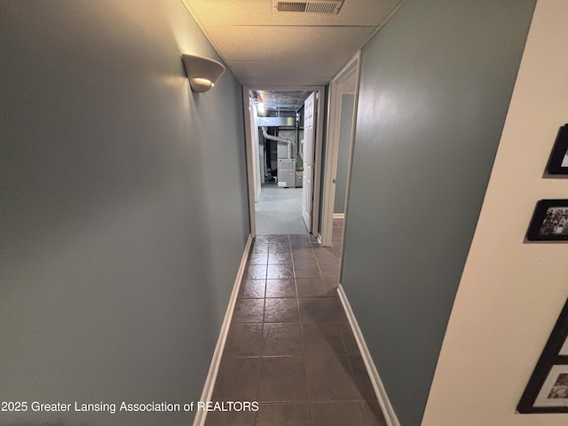 2665 Allium Dr, Holt, MI 48842 - hallway featuring dark tile patterned floors and baseboards