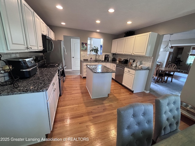2665 Allium Dr, Holt, MI 48842 - kitchen with stainless steel appliances, decorative backsplash, a center island, white cabinets, and recessed lighting