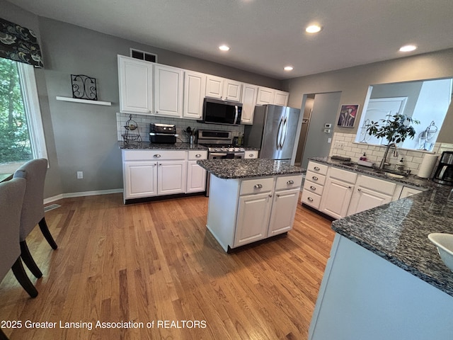 2665 Allium Dr, Holt, MI 48842 - kitchen featuring stainless steel appliances, light wood finished floors, tasteful backsplash, and recessed lighting