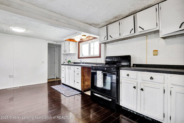 321 Lamb St, Perry, MI 48872 - kitchen with black range with gas stovetop, white cabinets, dark countertops, dark wood-type flooring, and a textured ceiling