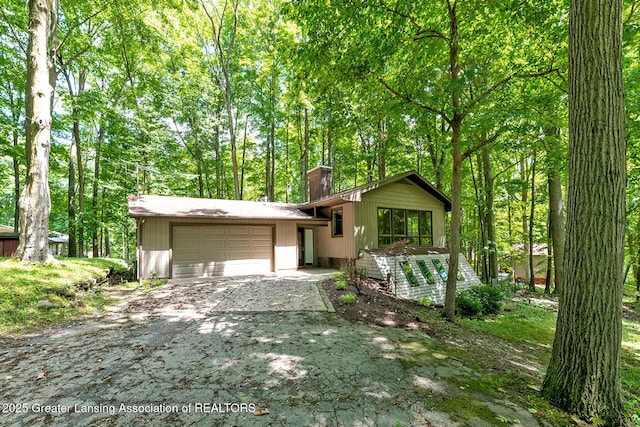 13368 Forest Hill Rd, Grand Ledge, MI 48837 - tri-level home with a garage, driveway, and a chimney