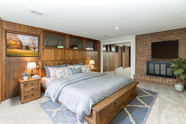 13368 Forest Hill Rd, Grand Ledge, MI 48837 - bedroom featuring carpet floors, wooden walls, a closet, and a fireplace