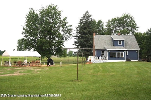 10996 Benton Rd, Grand Ledge, MI 48837 - view of grassy yard with a carport and a wooden deck