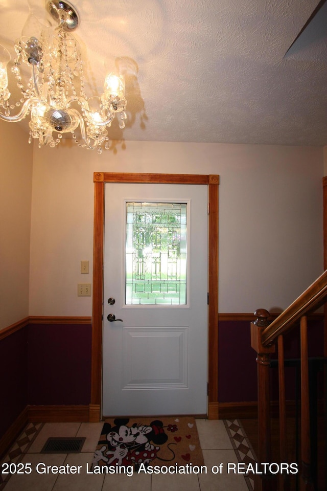 10996 Benton Rd, Grand Ledge, MI 48837 - tiled entryway with a chandelier and a textured ceiling
