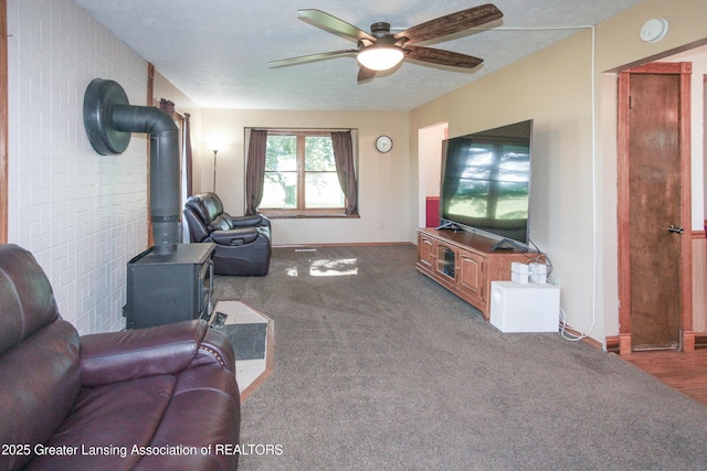10996 Benton Rd, Grand Ledge, MI 48837 - living room with a wood stove, a ceiling fan, and carpet flooring