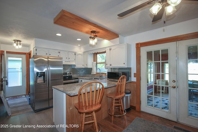 10996 Benton Rd, Grand Ledge, MI 48837 - kitchen with stainless steel appliances, a peninsula, white cabinets, dark wood-style flooring, and recessed lighting