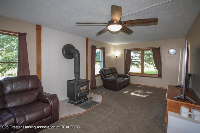 10996 Benton Rd, Grand Ledge, MI 48837 - living room featuring ceiling fan, a textured ceiling, a wood stove, and carpet flooring
