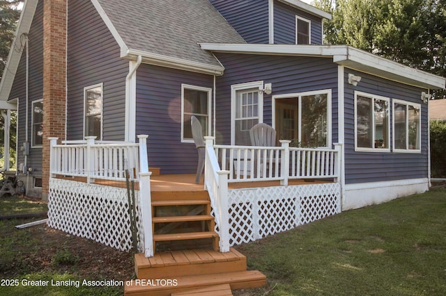 10996 Benton Rd, Grand Ledge, MI 48837 - back of property with a deck, a shingled roof, a yard, and a chimney